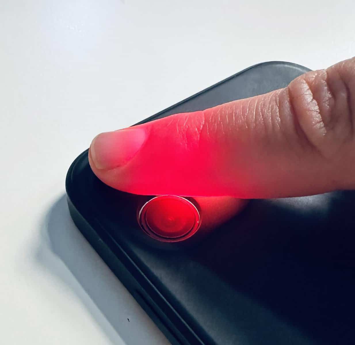 Finger, der von Smartphonekamera mit Licht durchleuchtet wird